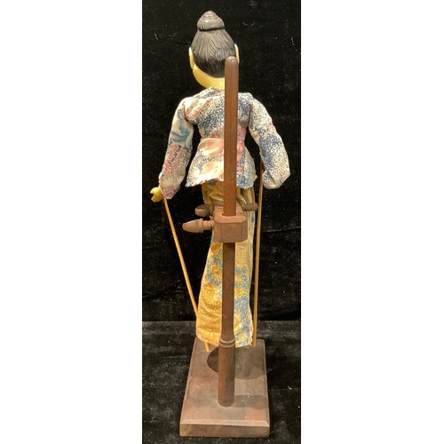 81 - An Indonesian Wayang Golek puppet, on stand, 55cm high overall