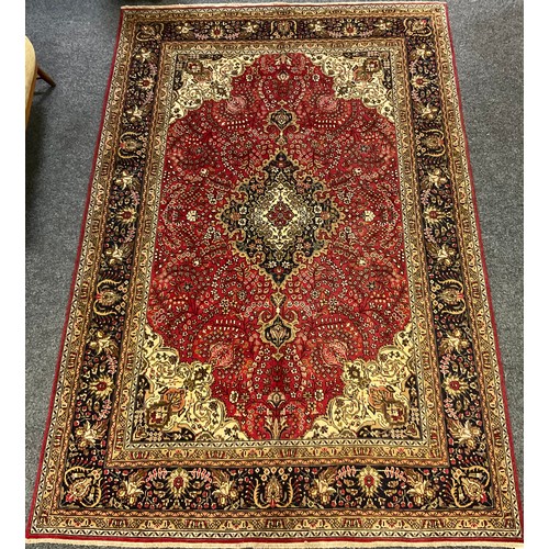 212 - A Persian Tabriz rug/carpet, central medallion within intricate floral field in tones of red, cream,... 