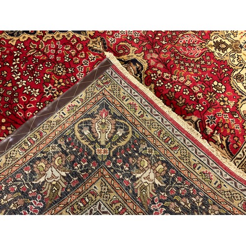 212 - A Persian Tabriz rug/carpet, central medallion within intricate floral field in tones of red, cream,... 