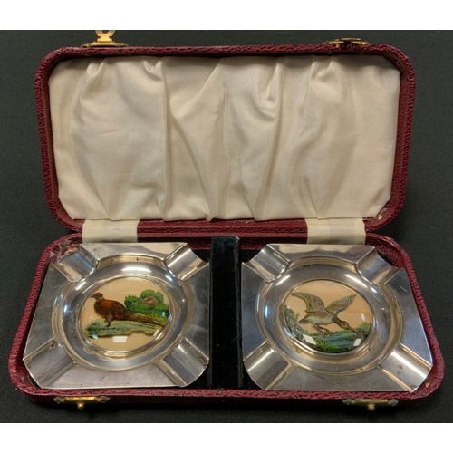 61 - A pair of E.P.N.S. canted square ashtrays, the centres with 'Essex Crystal' type intaglios, of a phe... 