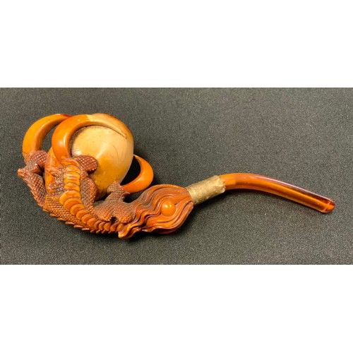 234 - A 19th century meerschaum pipe, carved as a dragon's claw grasping a pearl of wisdom, 17.5cm long, c... 