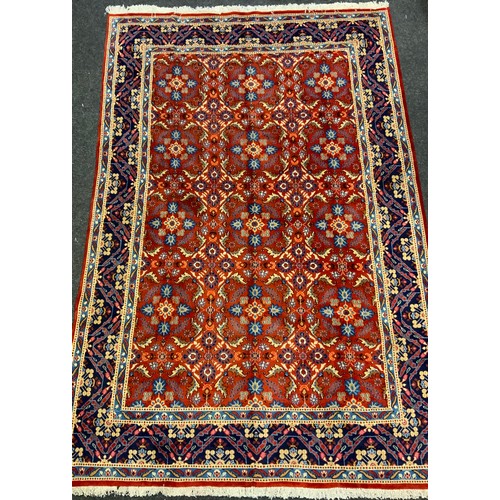 594 - A Persian Mashad hand-knotted rug / carpet, having a central field in rich red and Lapis blue, with ... 