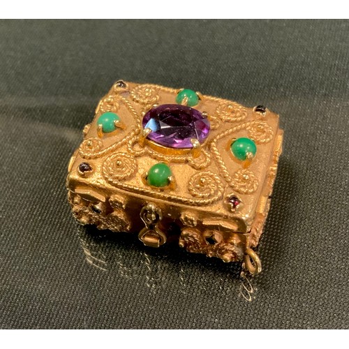 716 - An amethyst and green stone and garnet cabochon mounted gold coloured metal pill box, wirework scrol... 