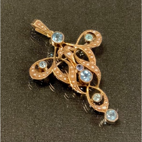 731 - An Art Nouveau seed pearl and aquamarine pendant/brooch, the serpentine scrolling frame inset with s... 