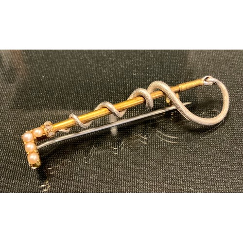 732 - A gold and silver coloured metal riding crop brooch, the handle set with four seed pearls and three ... 