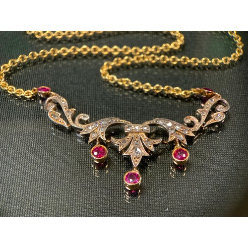 761 - An Edwardian diamond and ruby necklace, the scrolling floral body set with five vibrant red rubies a... 