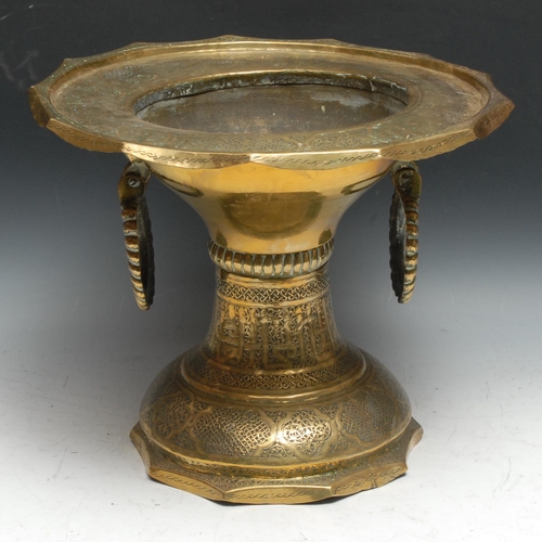 692 - A Middle Eastern brass pedestal brazier, profusely chased in the Islamic taste with Arabic script an... 