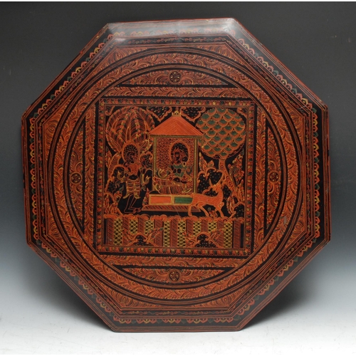 697 - A 20th century octagonal lacquered table top, decorated with deities, and feathered bands, 61cm wide