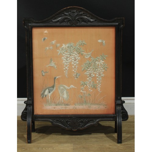 1338 - A late Victorian oak fire screen, the glazed banner with a Chinese silk panel worked on a peach grou... 