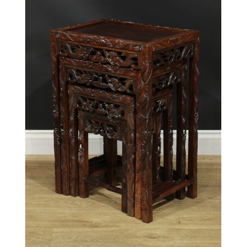 1117 - A set of Chinese hardwood quartetto tables, rectangular panel tops, the borders carved with ferociou... 