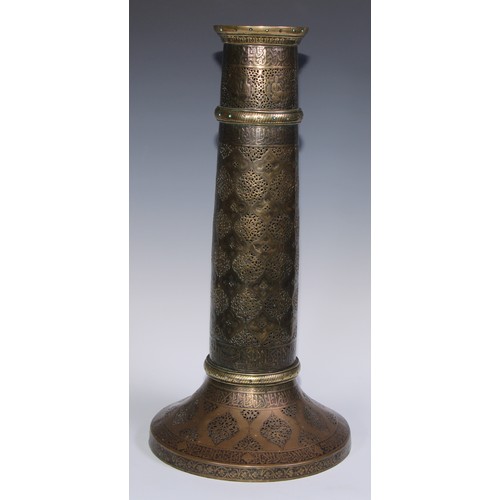 1191 - A pair of large Middle Eastern Islamic brass mosque candlesticks, pierced and engraved with a field ... 