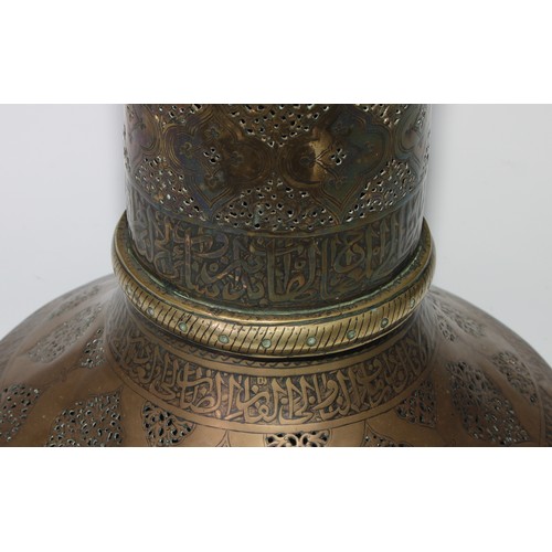 1191 - A pair of large Middle Eastern Islamic brass mosque candlesticks, pierced and engraved with a field ... 