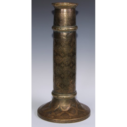 1191 - A pair of large Middle Eastern Islamic brass mosque candlesticks, pierced and engraved with a field ... 