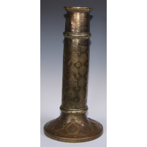 1191 - A pair of large Middle Eastern Islamic brass mosque candlesticks, pierced and engraved with a field ... 