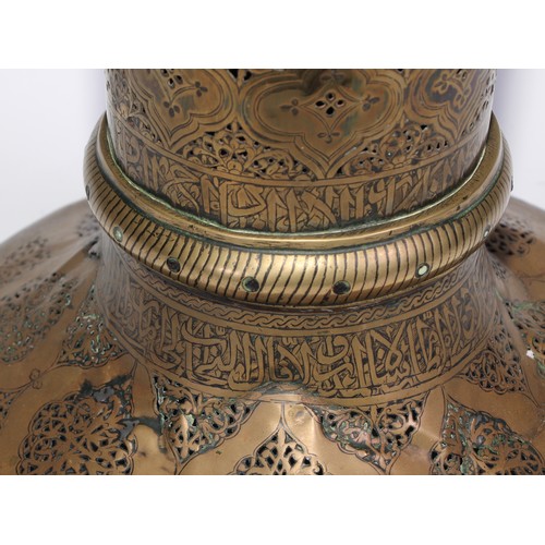 1191 - A pair of large Middle Eastern Islamic brass mosque candlesticks, pierced and engraved with a field ... 