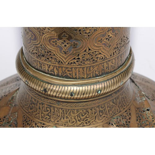 1191 - A pair of large Middle Eastern Islamic brass mosque candlesticks, pierced and engraved with a field ... 