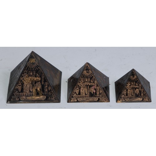 1145 - An Art Deco Egyptian Revival graduated trio of desk models, pyramids, the largest 4cm high