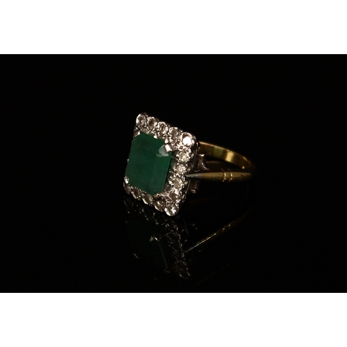 371 - An Art Deco style diamond and emeral ring, central rectangular stone claw set within eighteen round ... 