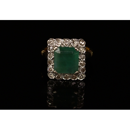 371 - An Art Deco style diamond and emeral ring, central rectangular stone claw set within eighteen round ... 