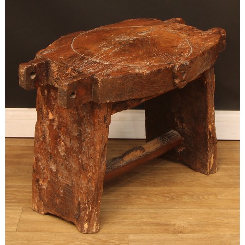 896 - A 19th century elm cheese or fruit press bed, carved with a primitive skull, 83cm wide, 44cm deep, l... 