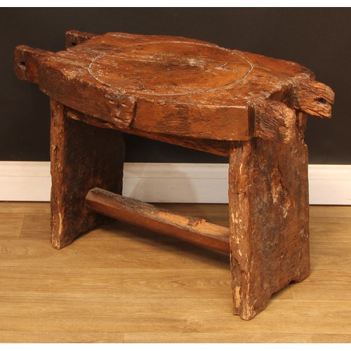 896 - A 19th century elm cheese or fruit press bed, carved with a primitive skull, 83cm wide, 44cm deep, l... 