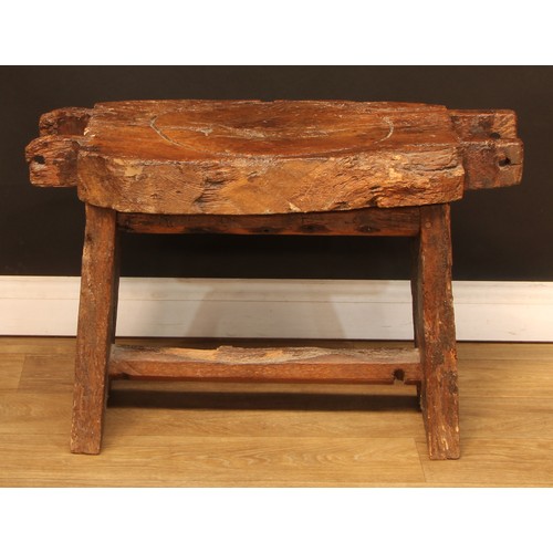 896 - A 19th century elm cheese or fruit press bed, carved with a primitive skull, 83cm wide, 44cm deep, l... 