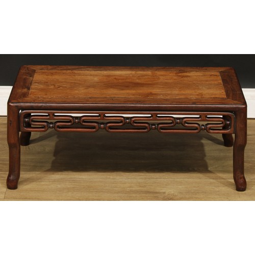 1031 - A Chinese hardwood kang or low tea table, rounded rectangular panelled top above a carved and pierce... 