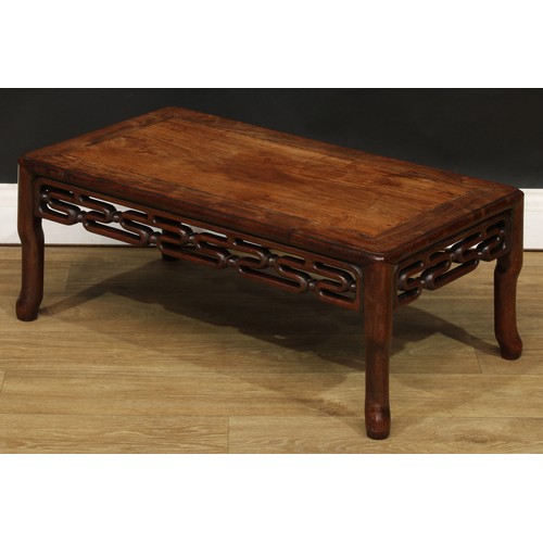 1031 - A Chinese hardwood kang or low tea table, rounded rectangular panelled top above a carved and pierce... 