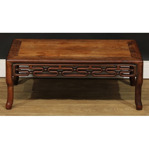 1031 - A Chinese hardwood kang or low tea table, rounded rectangular panelled top above a carved and pierce... 