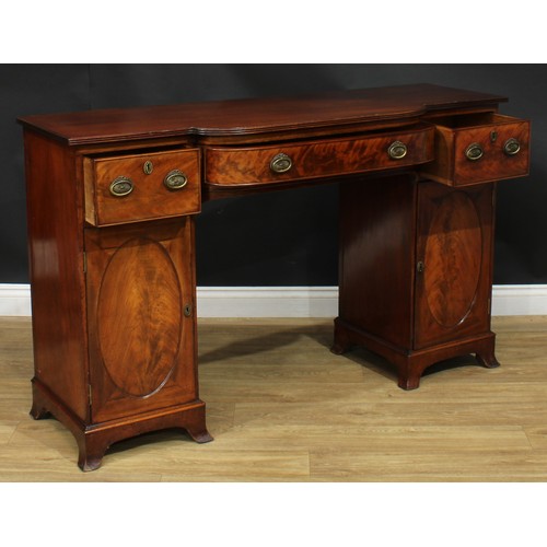 914 - A 19th century mahogany breakfront sideboard, slightly oversailing top with reeded edge above three ... 