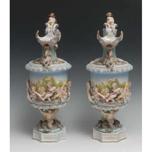 532 - A pair of Naples porcelain ewers, moulded in relief with putto and mythical beasts, 37.5cm high, c.1... 