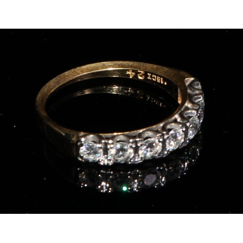 366 - An 18ct gold ring, set with a row of seven brilliant cut diamonds, size M, marked 18ct, 3.1g