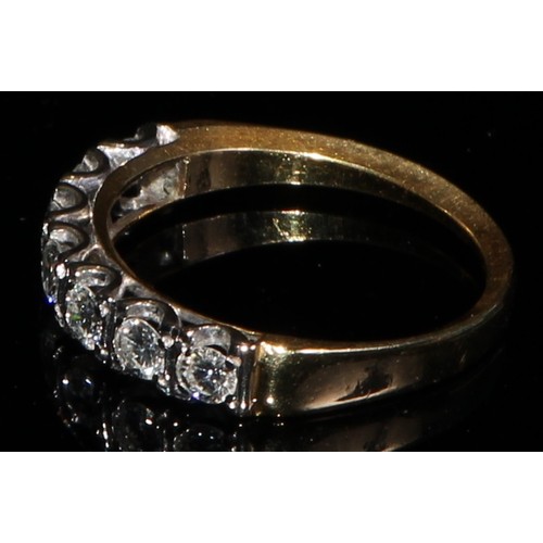 366 - An 18ct gold ring, set with a row of seven brilliant cut diamonds, size M, marked 18ct, 3.1g