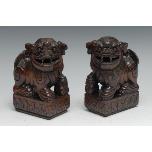 806 - A pair of Chinese hardwood figures or brackets, carved as temple dogs, to left and right, 15cm high,... 