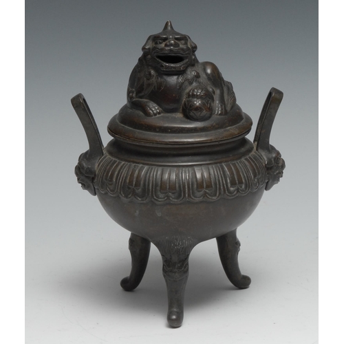 759 - A Chinese bronze tripod censer and cover, surmounted by a temple lion, lappet border, loop handles t... 