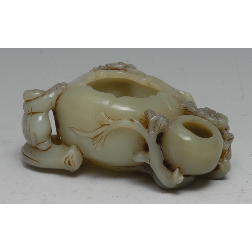 740 - A Chinese celadon jade brush washer, carved with a figure and blossom alongside a peach, 11cm wide