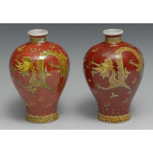 781 - A pair of Chinese meiping vases, decorated in tones of yellow and iron red with dragons chasing a fl... 