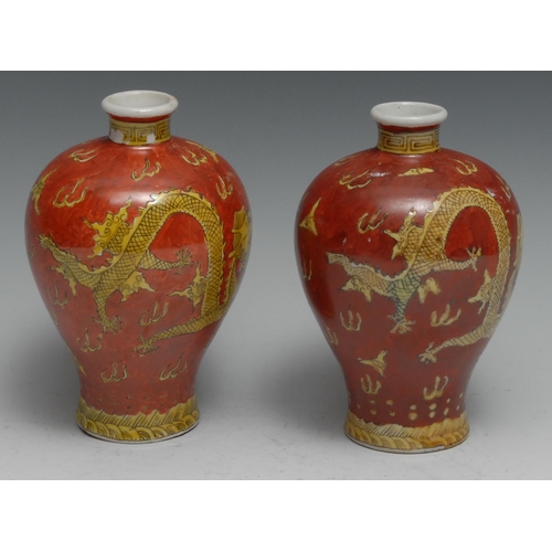 781 - A pair of Chinese meiping vases, decorated in tones of yellow and iron red with dragons chasing a fl... 