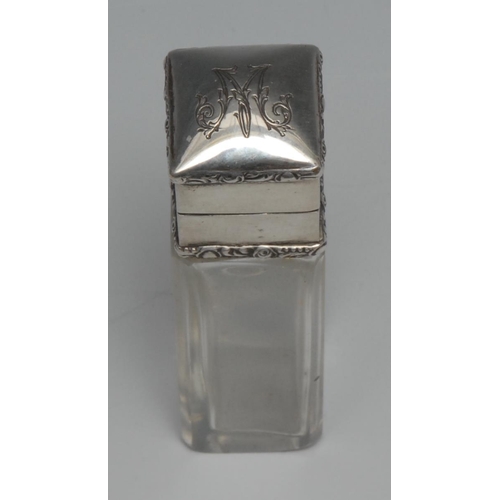 91 - A Continental silver mounted square clear glass scent bottle, hinged cover with applied foliate bord... 