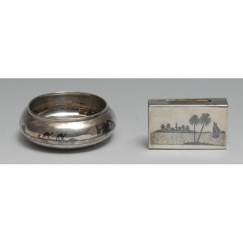 288 - An Iraqi silver and niello bowl or salt, typically decorated with desert scenes, 7cm diam; a matchbo... 