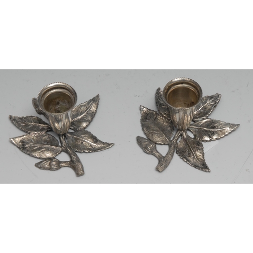 173 - A pair of Continental silver candlesticks, each base cast as a flowering branch, 7cm wide, marked 80... 