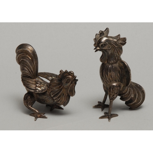 200 - A pair of silver coloured metal models, of cockerels, the tallest 8cm high, apparently unmarked, ear... 