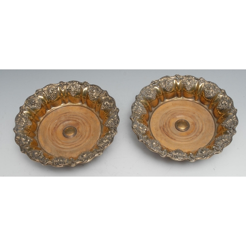 28 - A pair of Regency gilded Old Sheffield plate fluted shaped circular wine coasters, fruiting vine bor... 