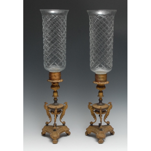 1197 - A pair of Regency gilt and parcel dark patinated bronze storm lanterns, each with Greek key collar a... 