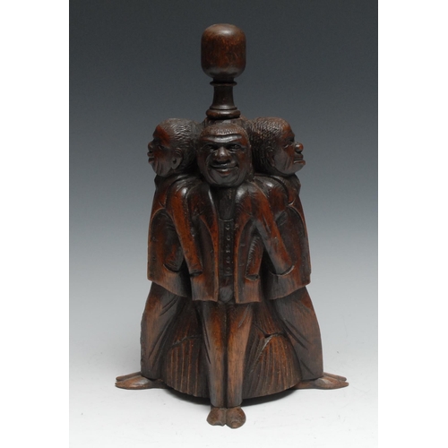 1067 - A 19th century oak door stop, amusingly carved as four figures, each with his hand in his fellow’s p... 