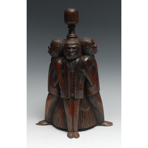 1067 - A 19th century oak door stop, amusingly carved as four figures, each with his hand in his fellow’s p... 