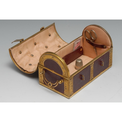 1153 - An early 20th century brass mounted red morocco leather sewing casket, as a domed trunk, the hinged ... 