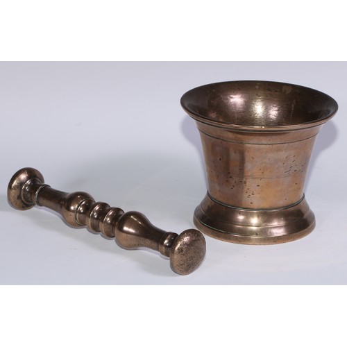 1141 - An 18th century bronze pestle and mortar, flared rim, skirted base, the mortar 14cm high, the pestle... 