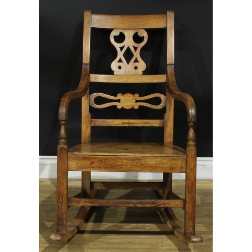 902 - A 19th century fruitwood rocking chair, shaped and pierced splat, downswept arms, 91cm high, 57cm wi... 