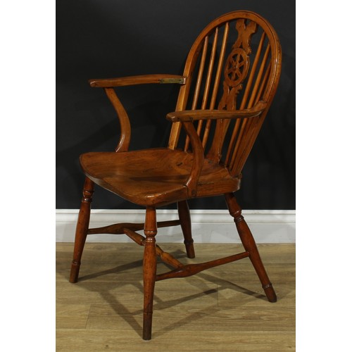 897 - A 19th century elm wheelback Windsor elbow chair, hoop back, shaped and pierced splat, saddle seat, ... 